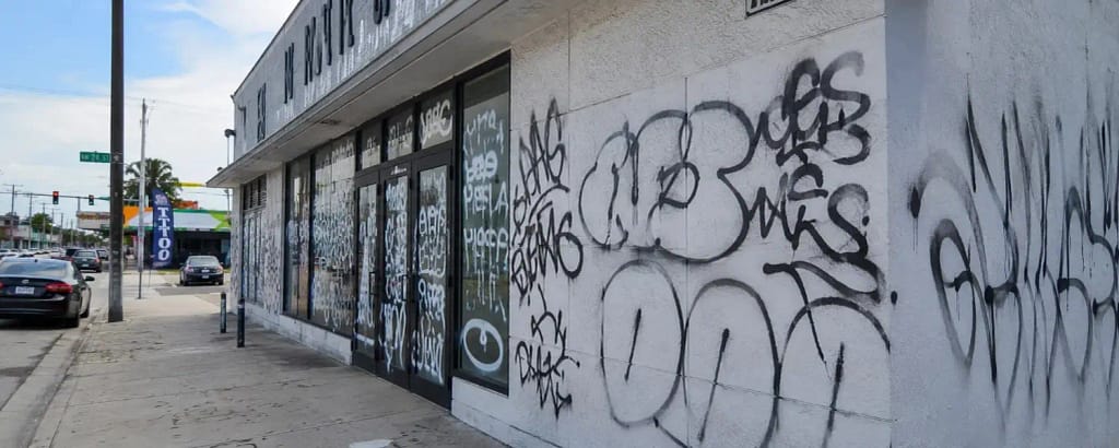 Graffiti vandalism on commercial storefront exterior in Miami FL