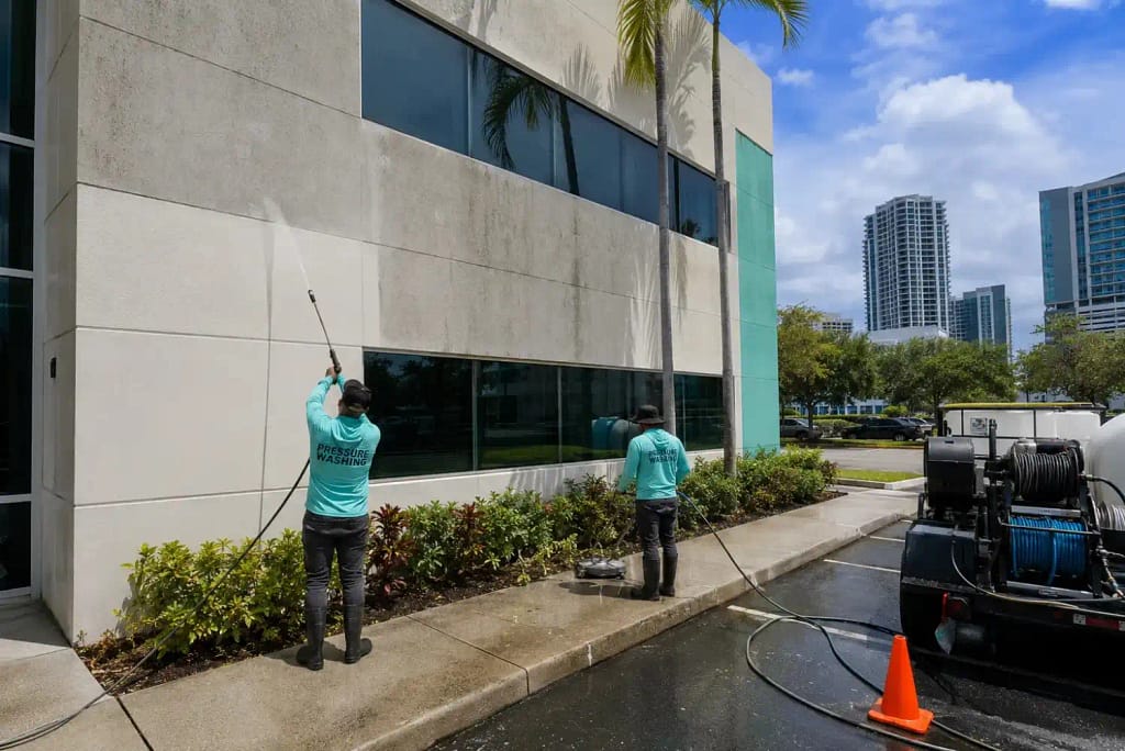 The Hidden Costs of Ignoring Commercial Cleaning Services in Miami 4 Professional crew pressure washing commercial building exterior in Miami FL
