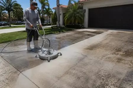 Driveway Replacement vs. Restoration: The $8,000 Question 3 Professional pressure cleaning a stained concrete driveway in Miami FL